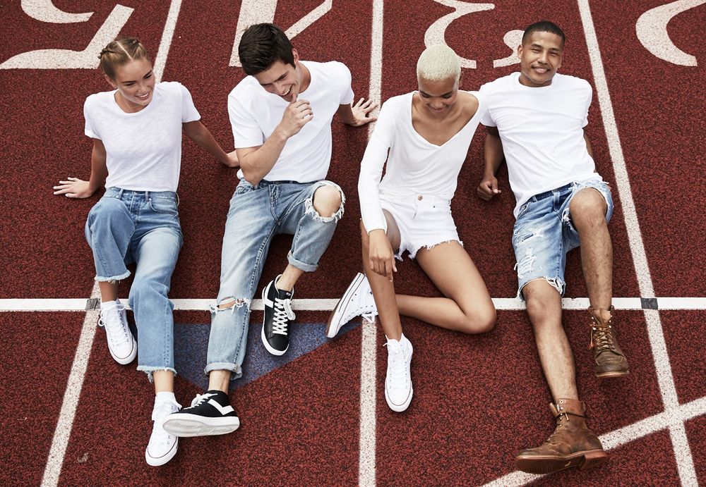 People sitting on a red high school running track.