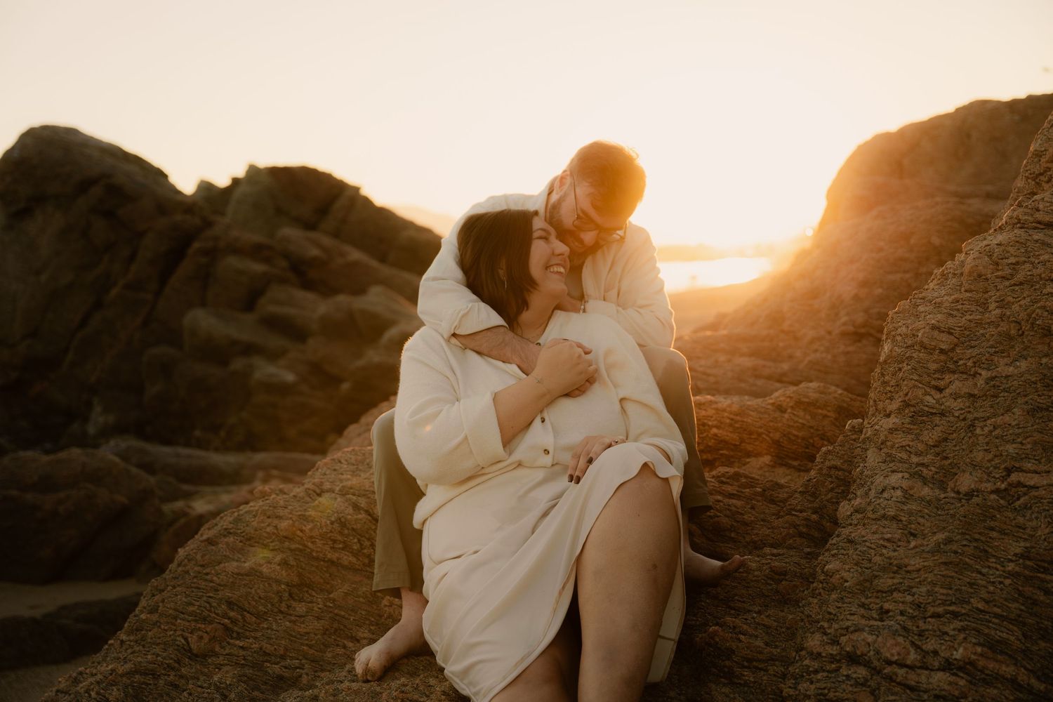 Photographe à cannes la bocca - Séance photo d'un couple assis sur des rochers au coucher du soleil