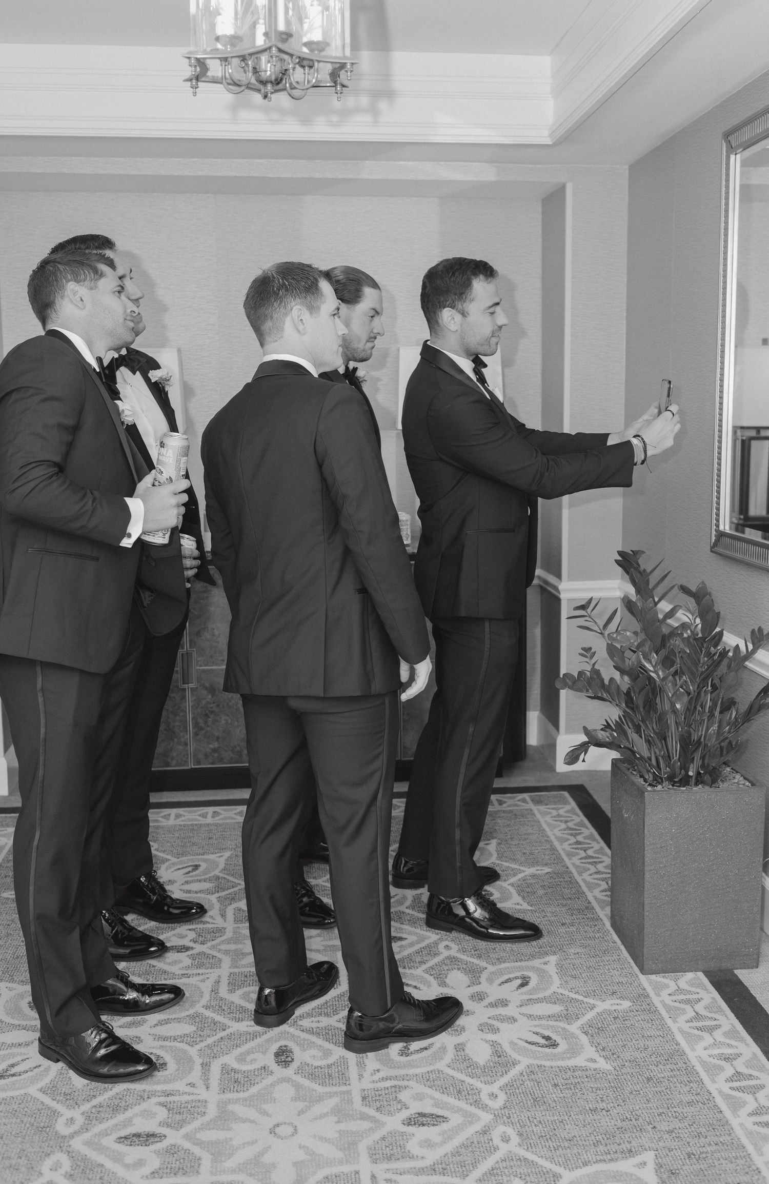 A sequence of black and white photos showing people in suits bending down in a hallway with patterned carpet.