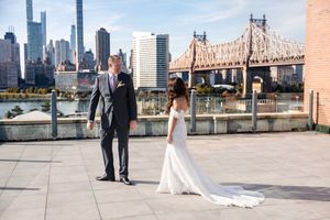 Bride and groom share a first look on a rooftop with NYC skyline and Queensboro Bridge backdrop.