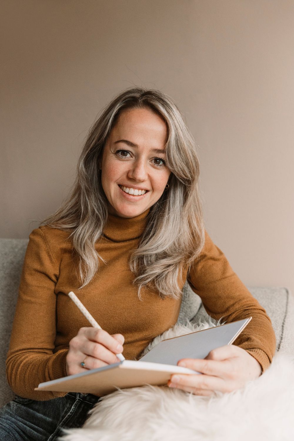 Casual home office setup with notebook and warm turtleneck sweater.