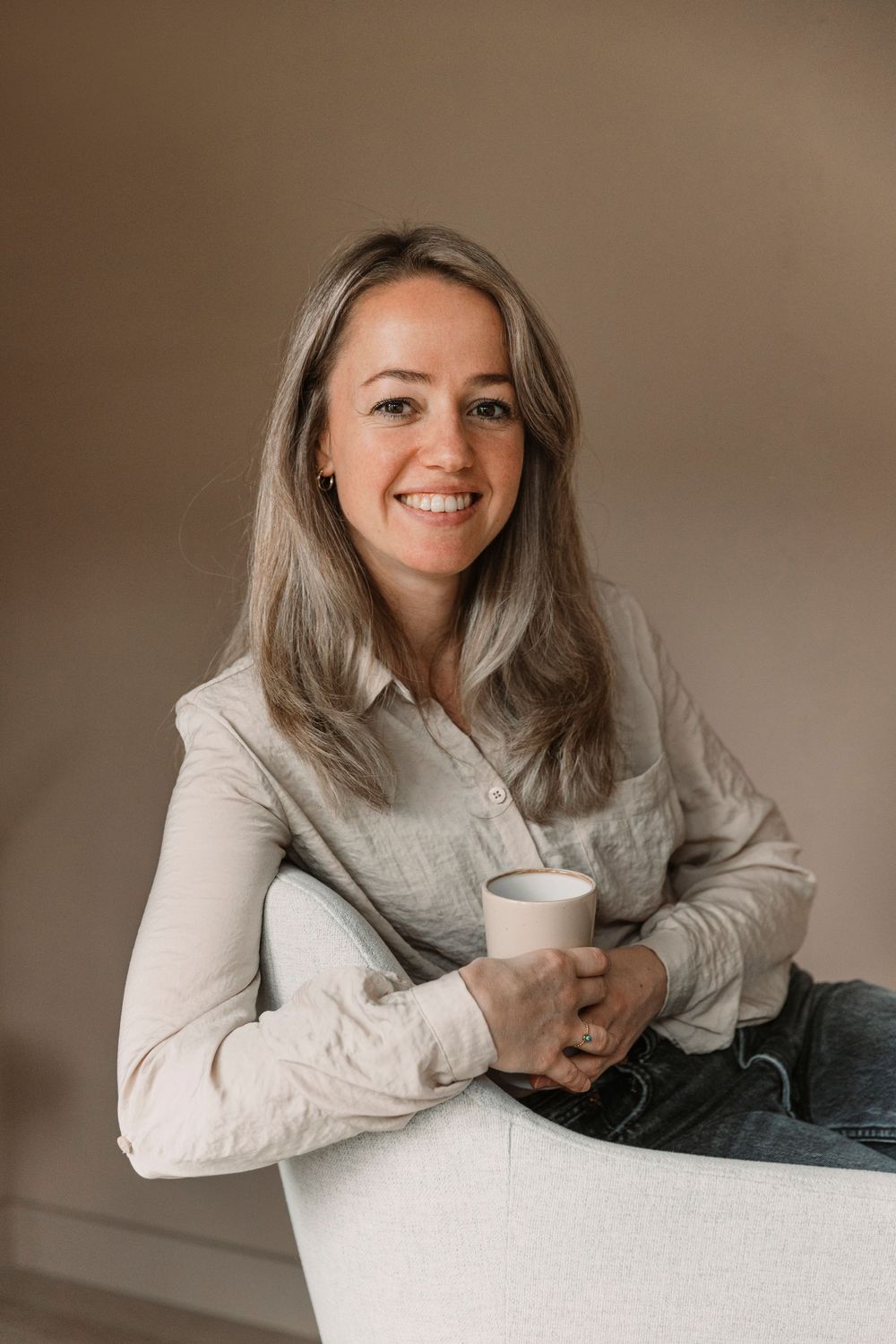 Casual indoor portrait with coffee cup in modern living space.
