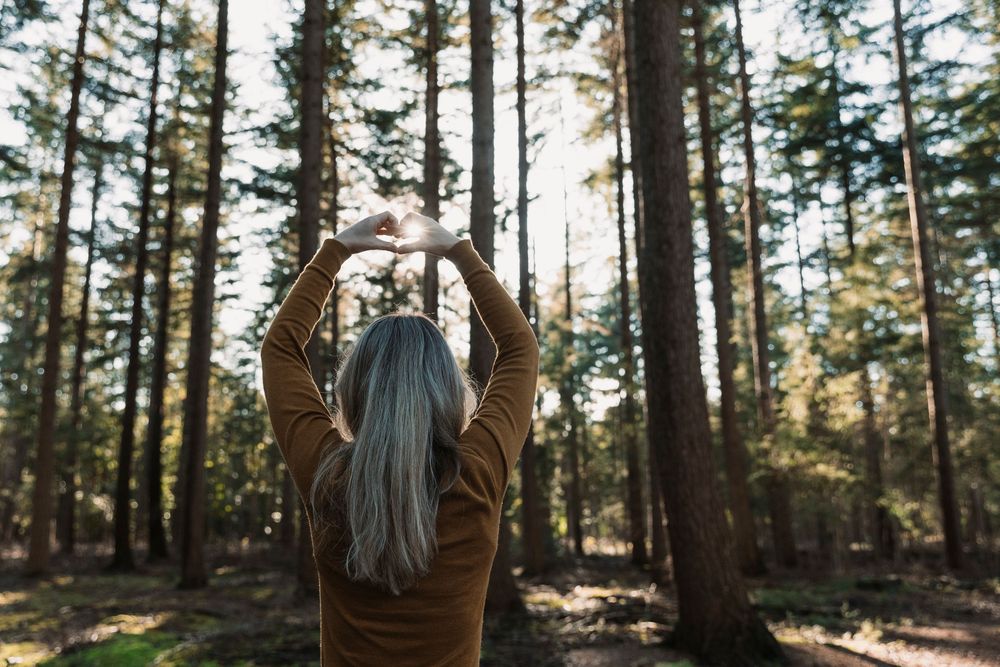 Joyful movement captured in forest setting with sunlight streaming through trees.