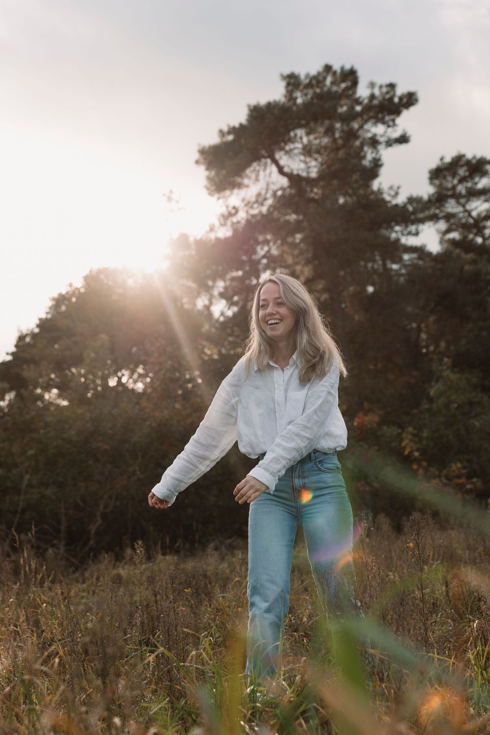 Candid moments in a golden meadow with light flares and natural scenery.