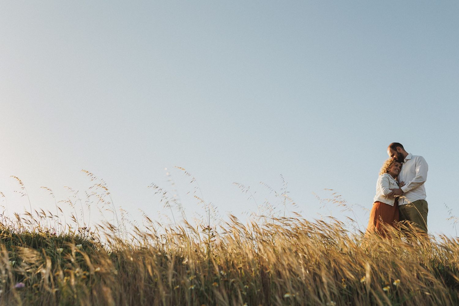 Couple walking with dog along coastal trail at Praia da Foz Portugal engagement session