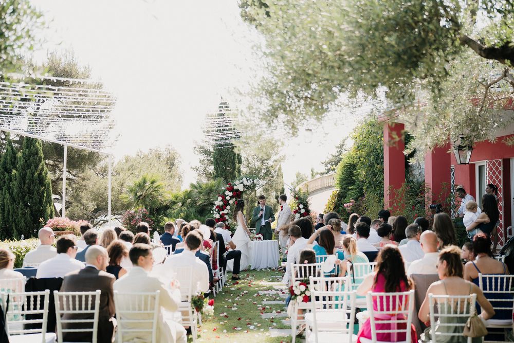 Wedding ceremony in the garden of Villa Casa Rossa in Imperia with guests seated overlooking the sea.