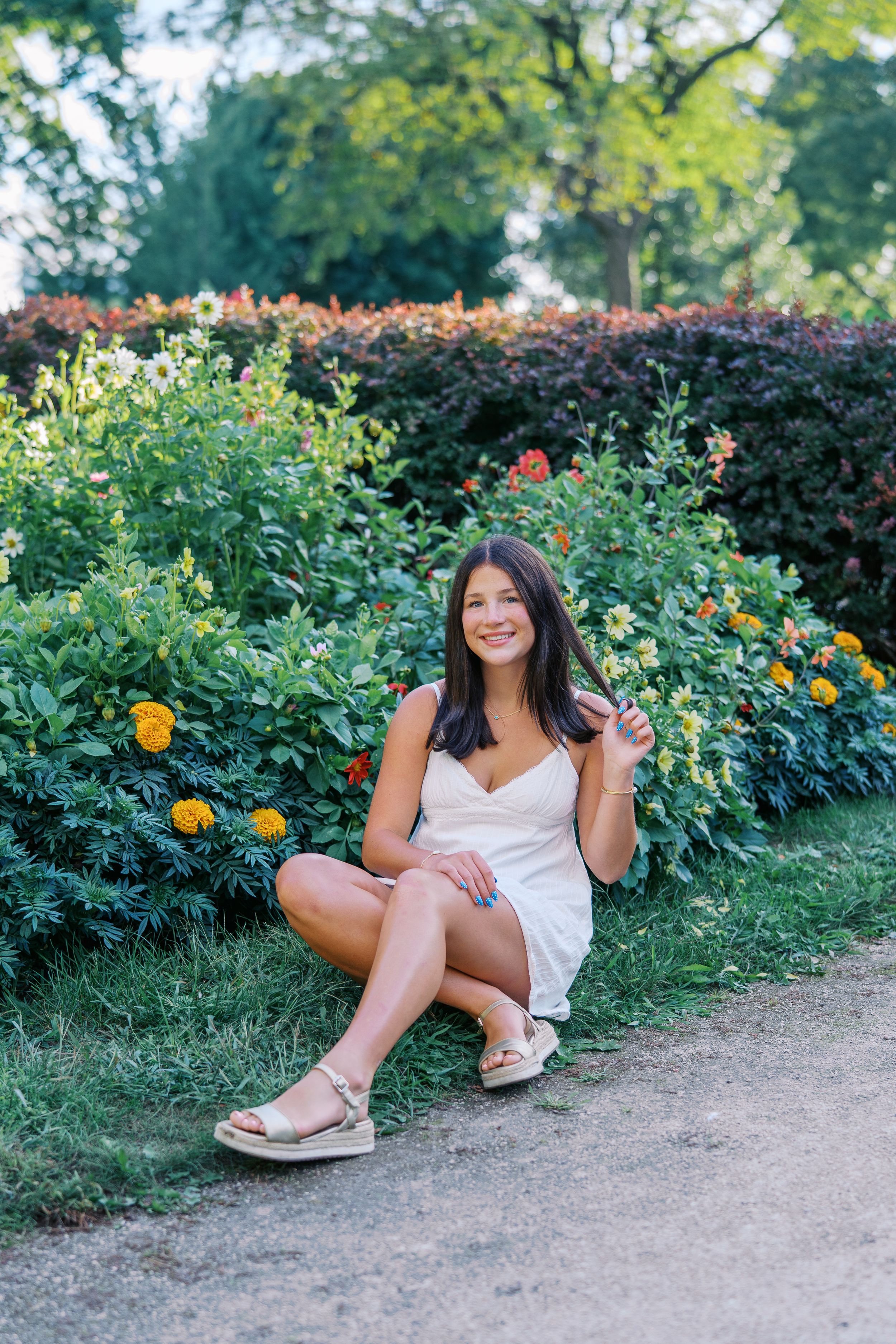 Candid shots taken in a lush garden setting with yellow and orange flowers along a dirt path.