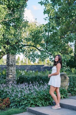 A collection of outdoor portraits taken near stone walls and purple flowering plants in a garden.