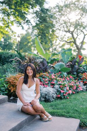 Garden photoshoot featuring pink flowers and tropical plants along a stone pathway.