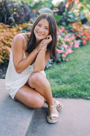 Casual outdoor portraits taken on a garden path surrounded by pink and red flowers.