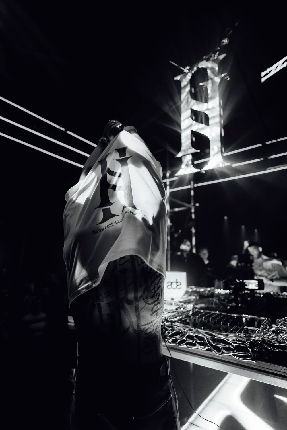 DJ working the turntables in dramatic black and white lighting.