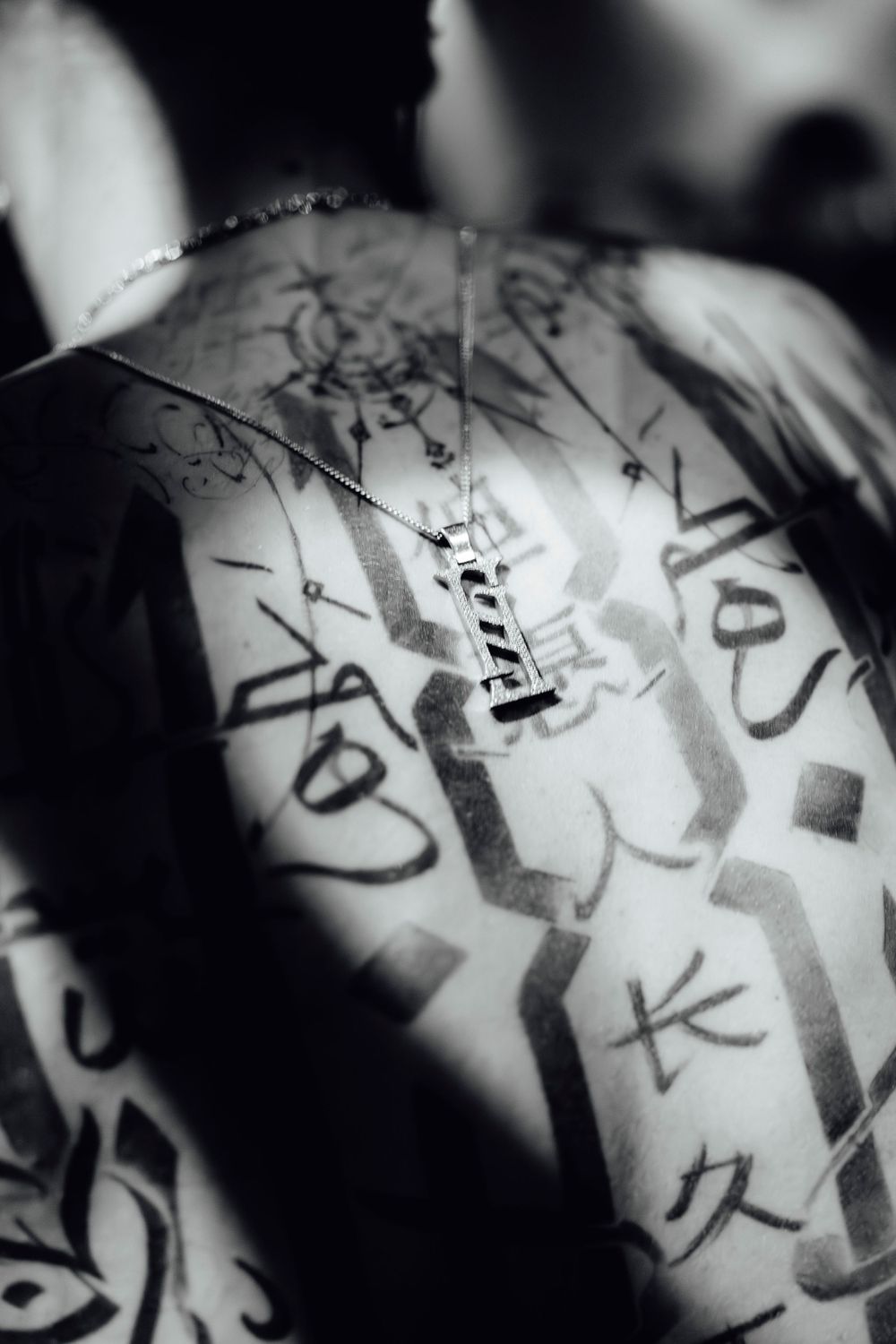 Abstract black and white pattern with handwritten text and geometric shapes in a blurred style.