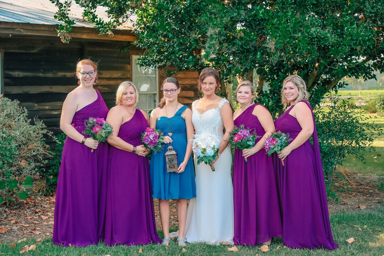 Bride with bridesmaids in elegant purple dresses, Amherstburg venue. Photographed by Tasha Cannaday.