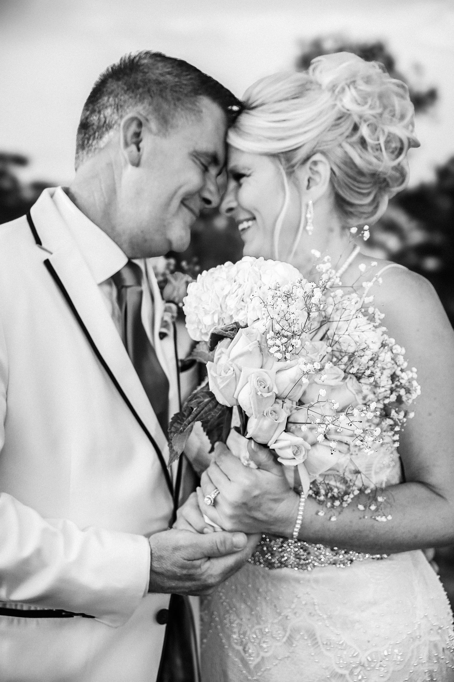 Black and white photo of couple embracing their love after renewing vows outdoors, photo taken by Tasha Cannaday in Amherstburg.
