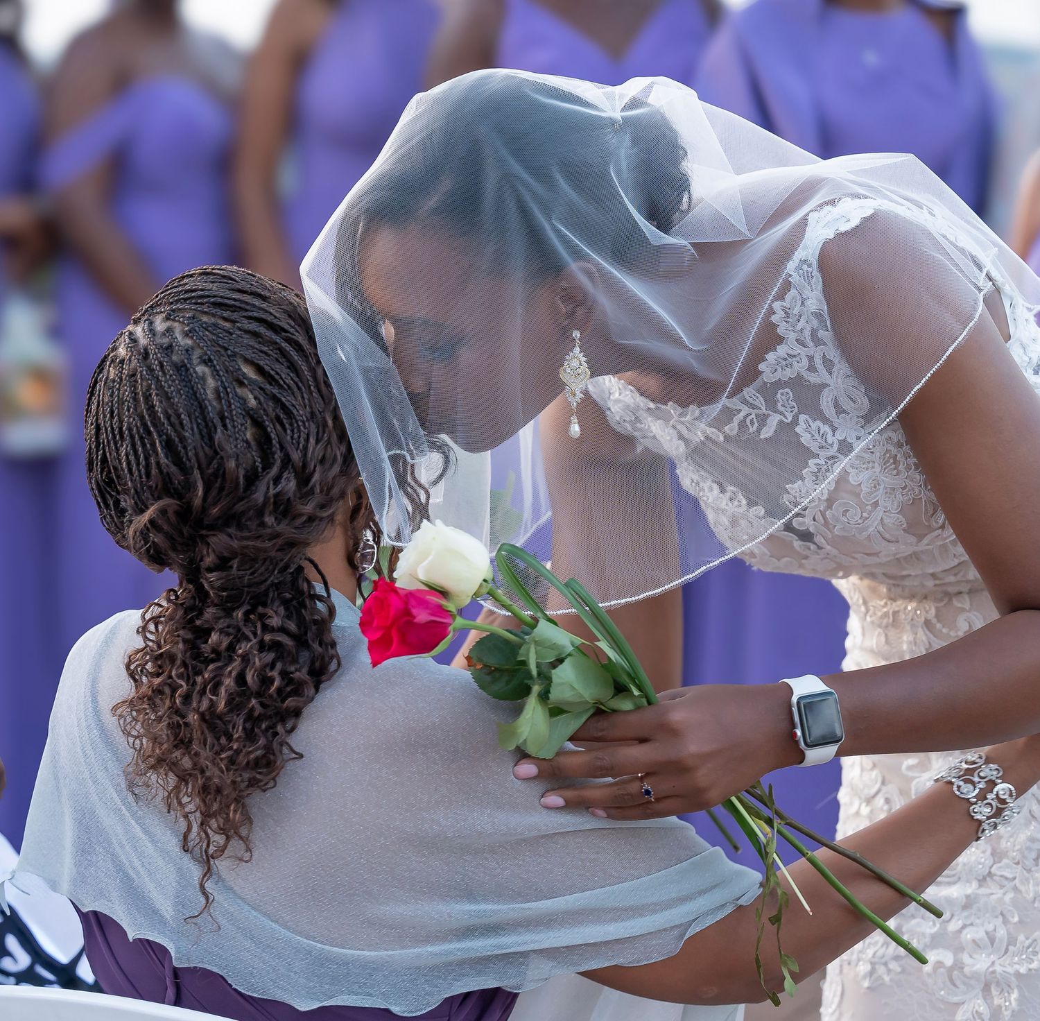 Lovely African American bride holding roses  and kissing her mother during her Highland Forest wedding ceremony by CNY Photography.