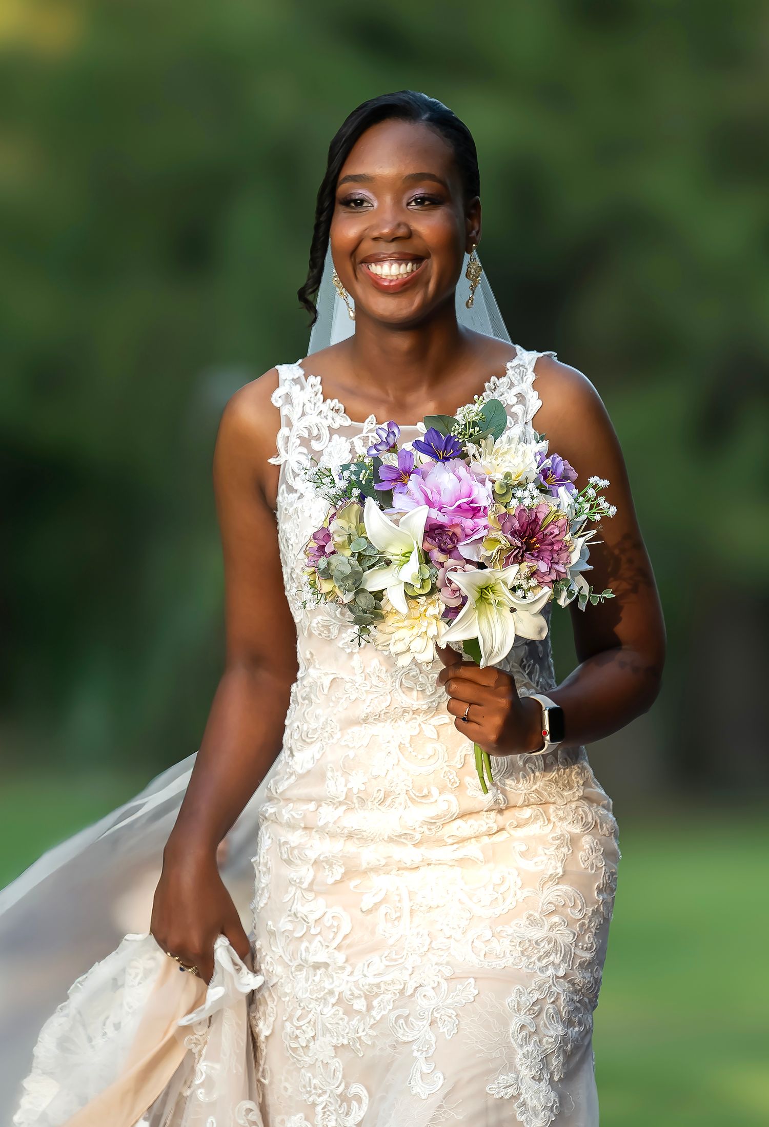Beautiful African American Bride smiling and walking towards the camera in her gown on her wedding day at Highland Forest in Central NY.