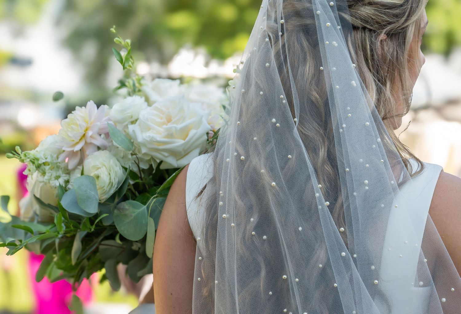 View from behind of a beautiful bride in her pearled veil as she holds her wedding bouquet at The Sherwood Inn, Skaneateles, CNY Photography