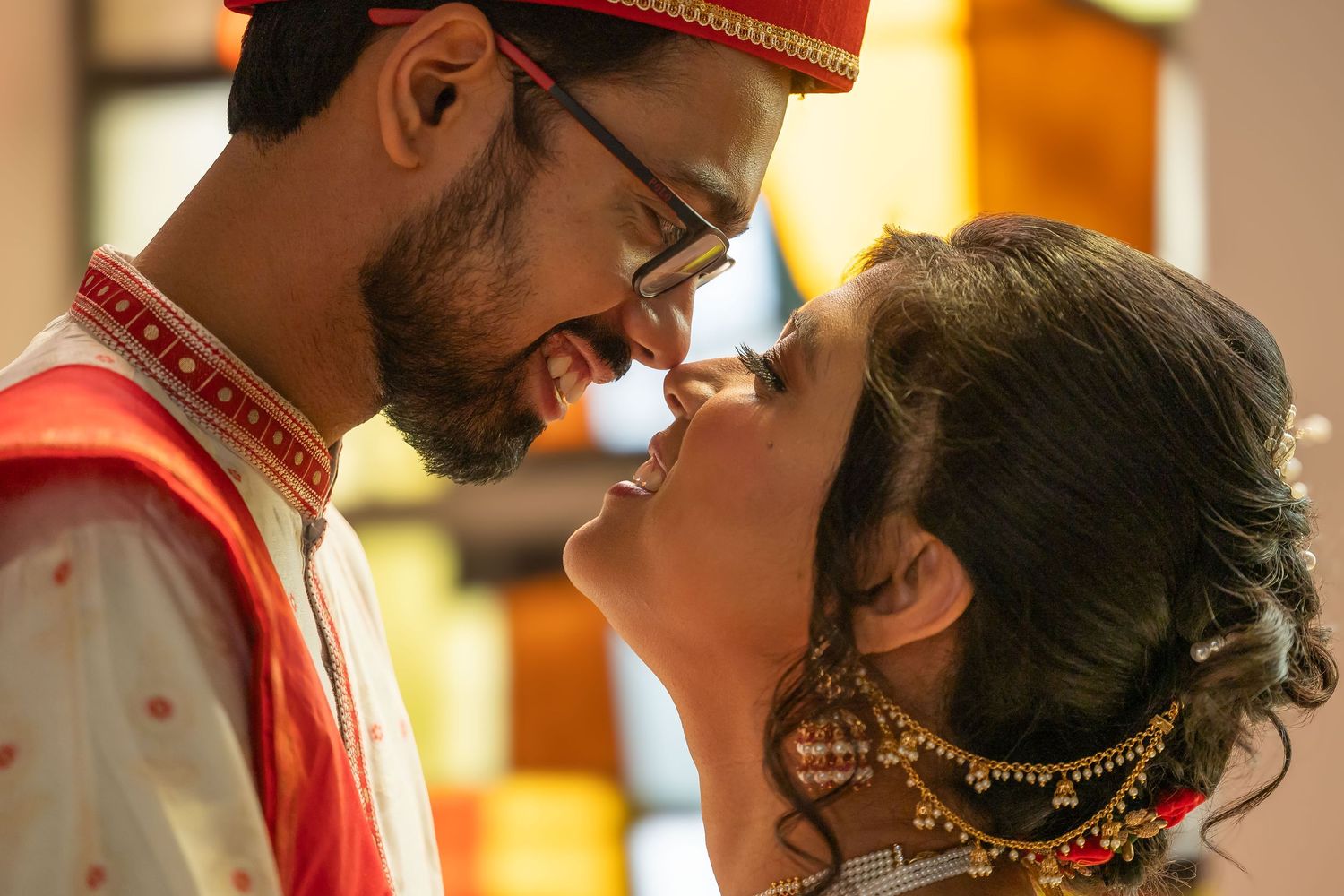 Indian bride and groom in traditional wedding attire sharing an intimate moment during their ceremony.