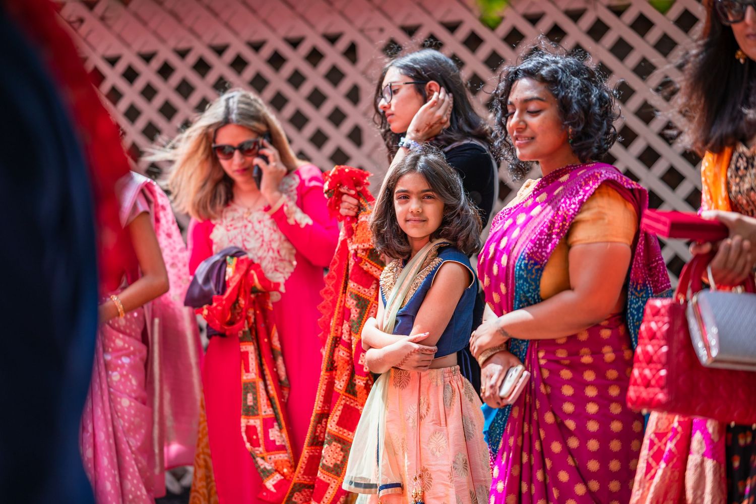 Guests in colorful Indian attire attending an outdoor wedding ceremony celebration.