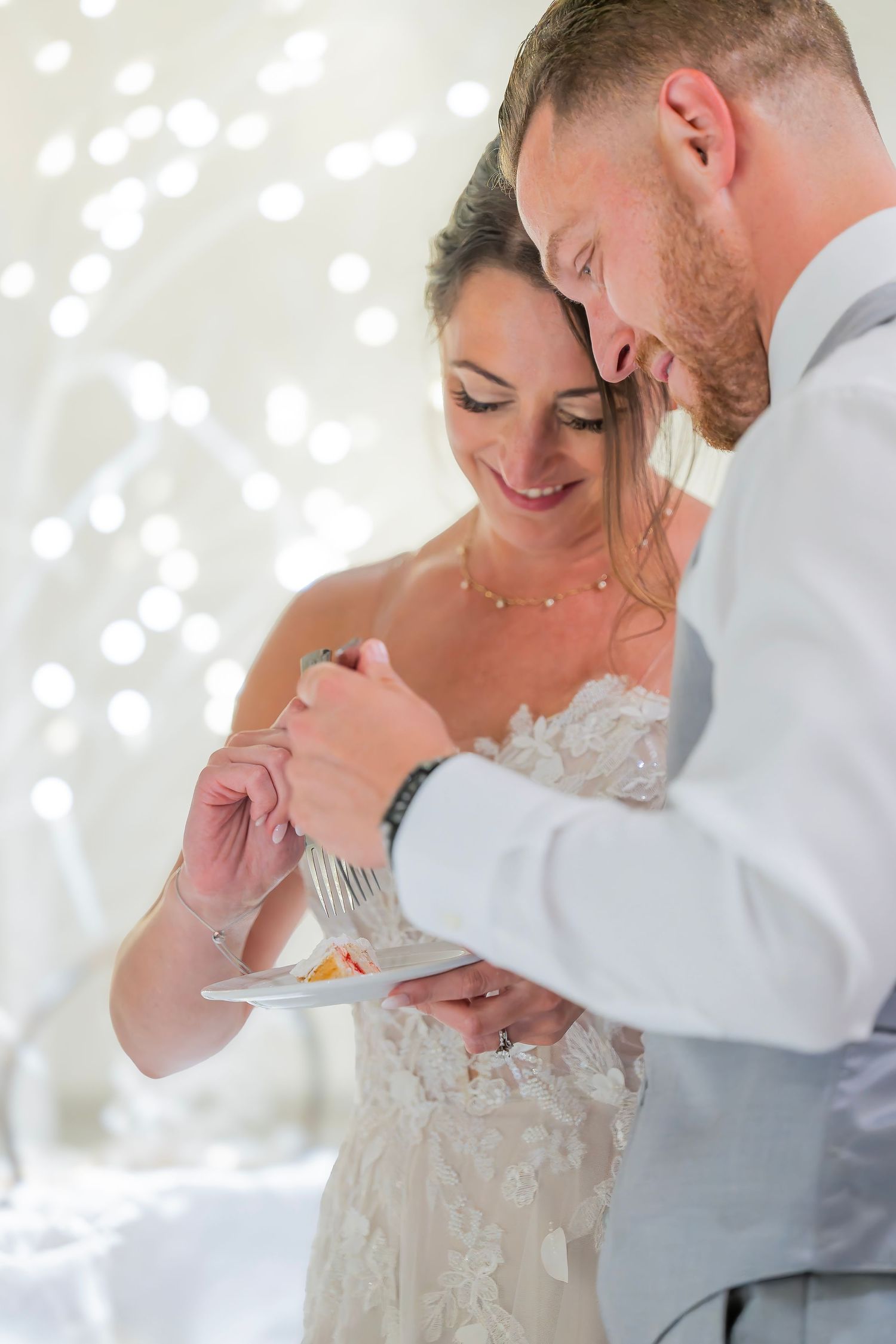Romantic soft lit wedding moment when this couple shares their wedding cake at their reception, wedding venue Beeches Manor in Rome NY.