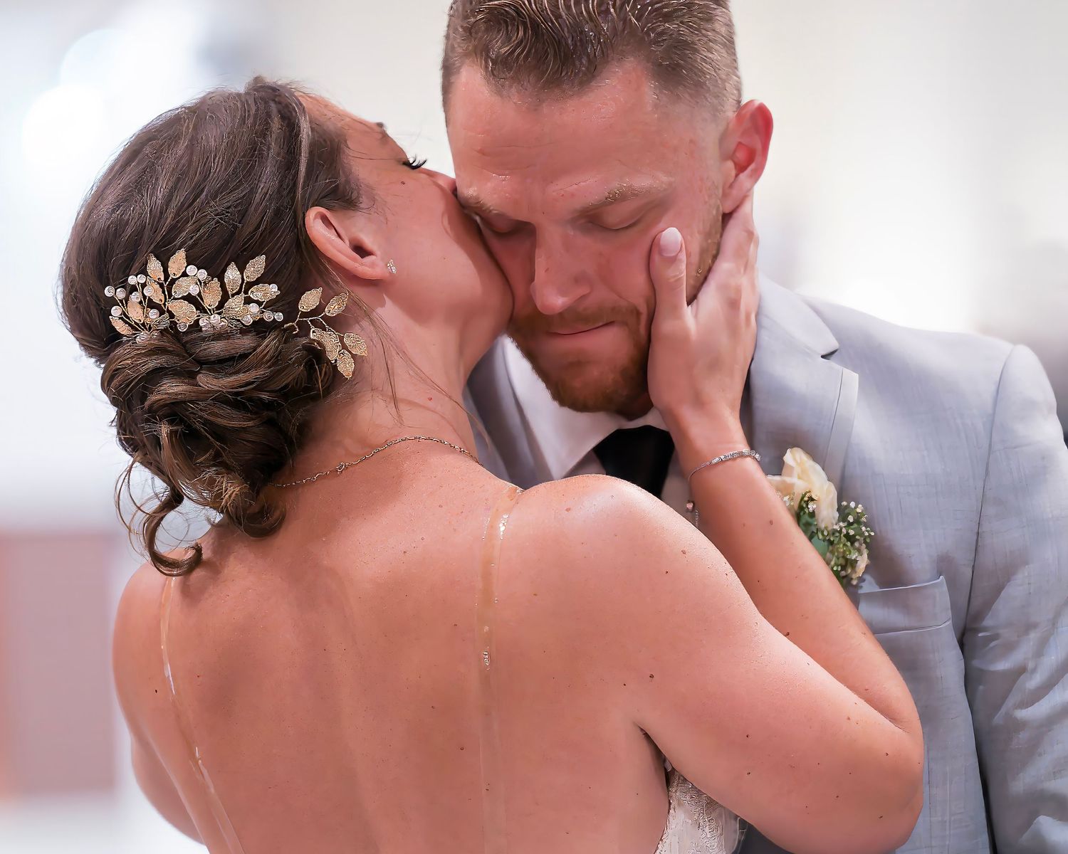 "Romantic wedding photo of bride Alyssa kissing groom Brad during their first dance, her hand on his cheek, showcasing love and happiness"