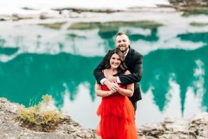 A joyful embrace captured against the backdrop of a pristine turquoise mountain lake.