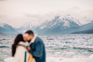 Blurred romantic silhouette against dramatic mountain lake landscape.