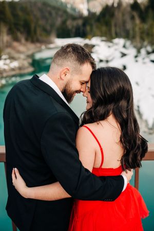 Intimate moment captured on viewing platform overlooking turquoise mountain lake.