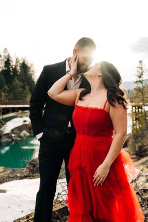 A romantic moment captured against a backdrop of turquoise water and mountains.