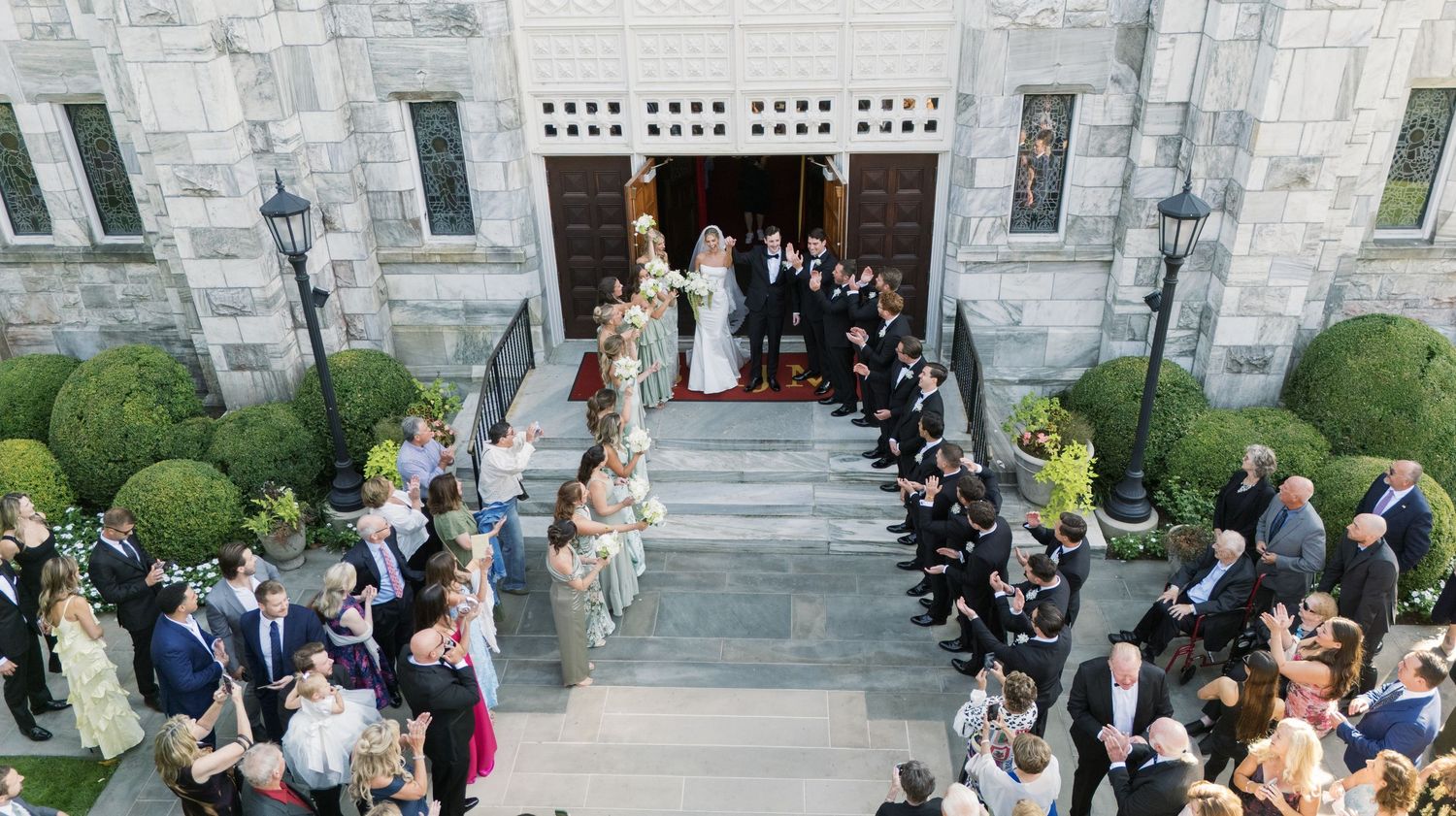 Guests seated at elegant outdoor tables with cathedral spires and gothic architecture in the background.