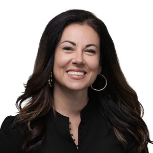Professional headshot portraits of a person in black clothing against a dark background showing various smiling expressions.