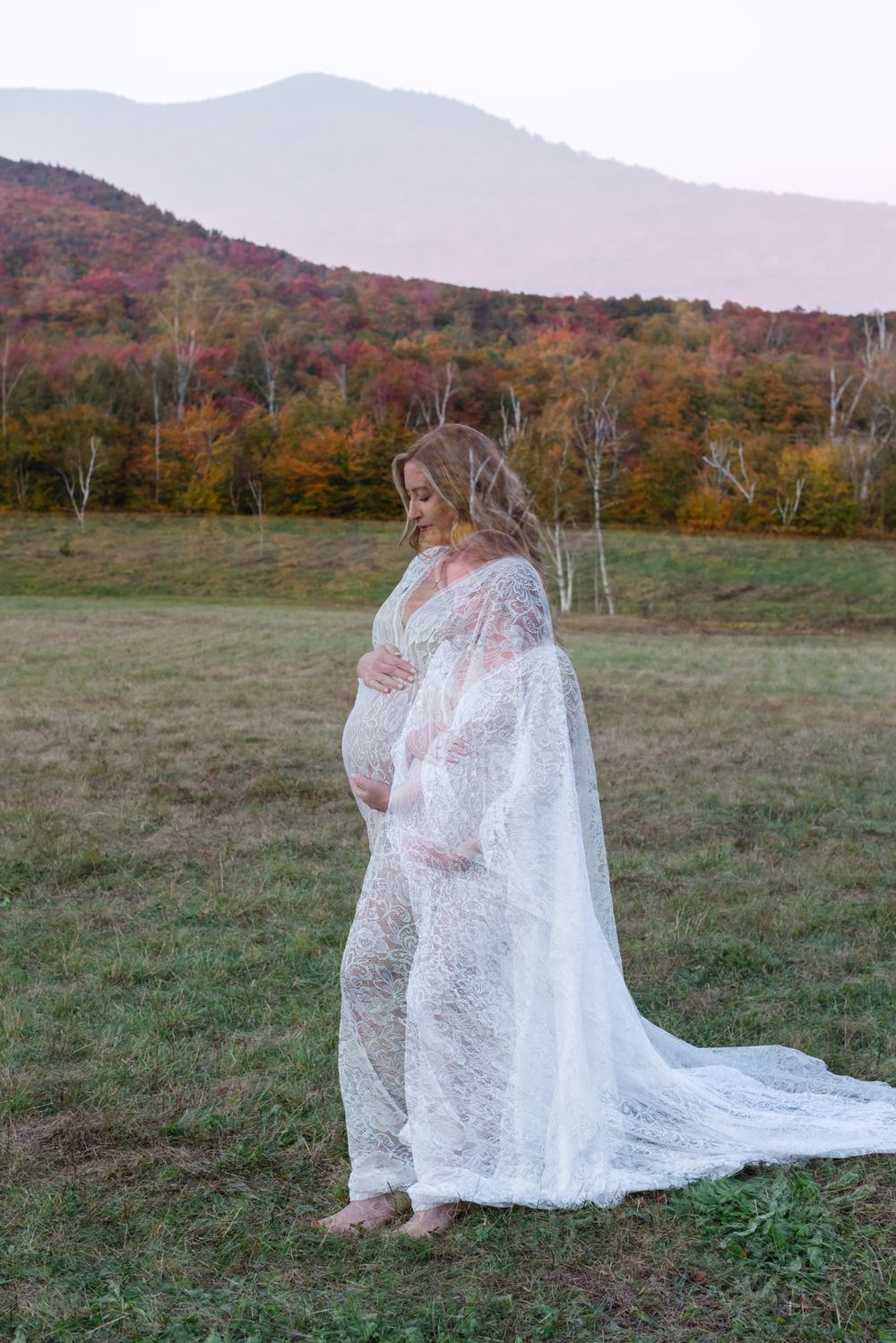 Double exposure of expectant mother wears white lace dress against mountain fall foliage for maternity photos. Lenox maternity photographer