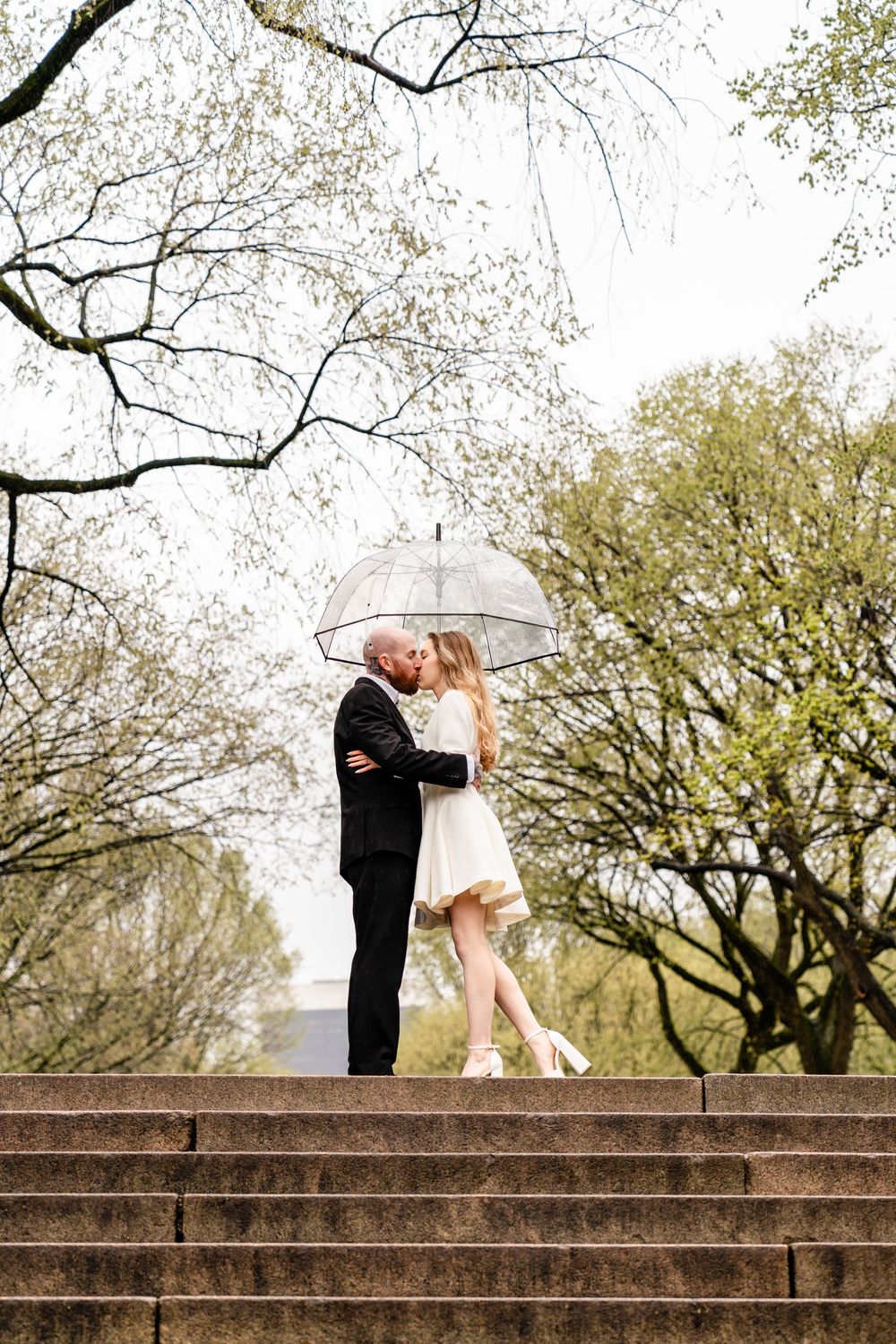Romantic rainy day couple portrait in Central Park with transparent umbrella