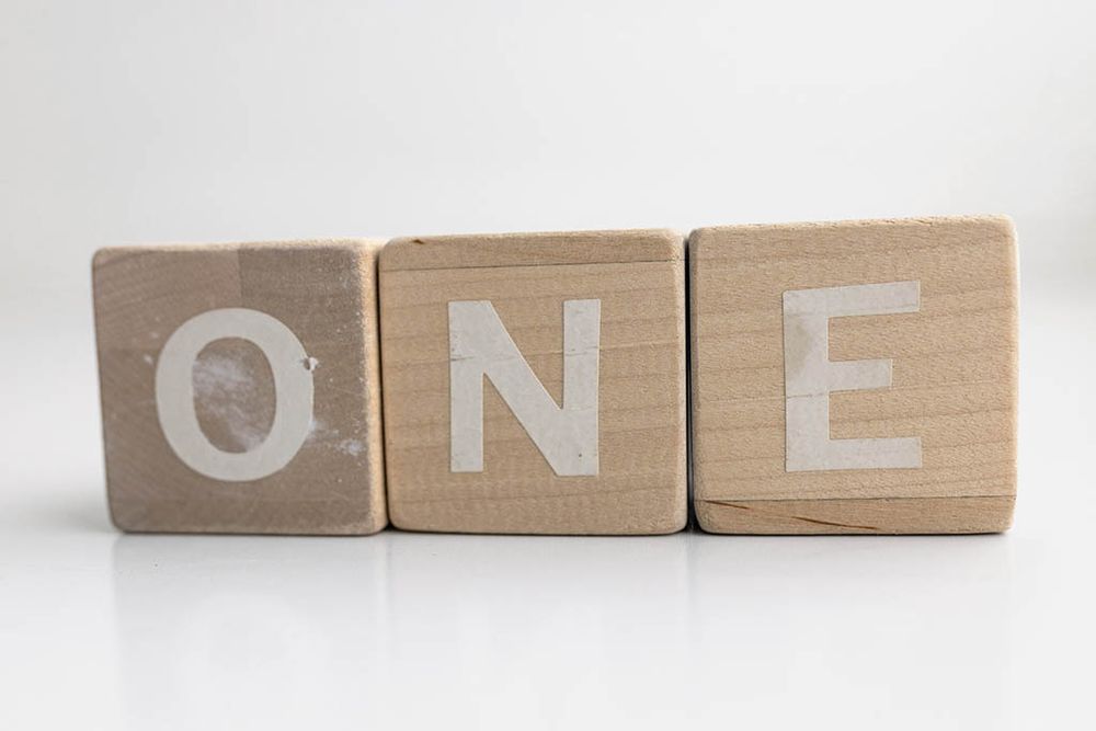 Three wooden blocks spelling ONE; props for Menifee photographer capturing first birthdays and milestones.