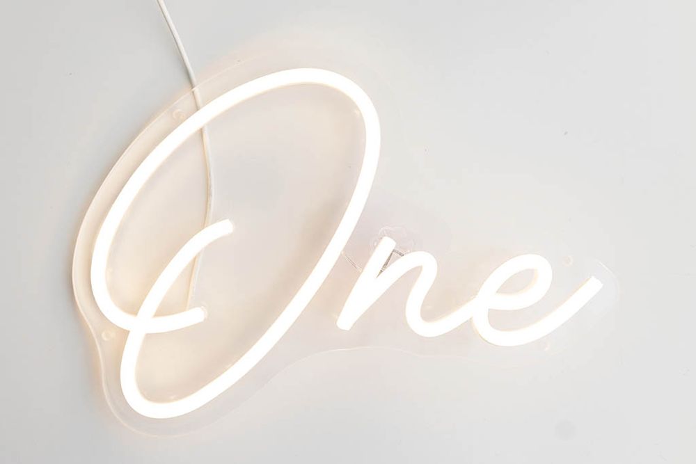 White neon light sign spelling One in cursive script; Menifee Baby's First Birthday Cake Smash Photographer.
