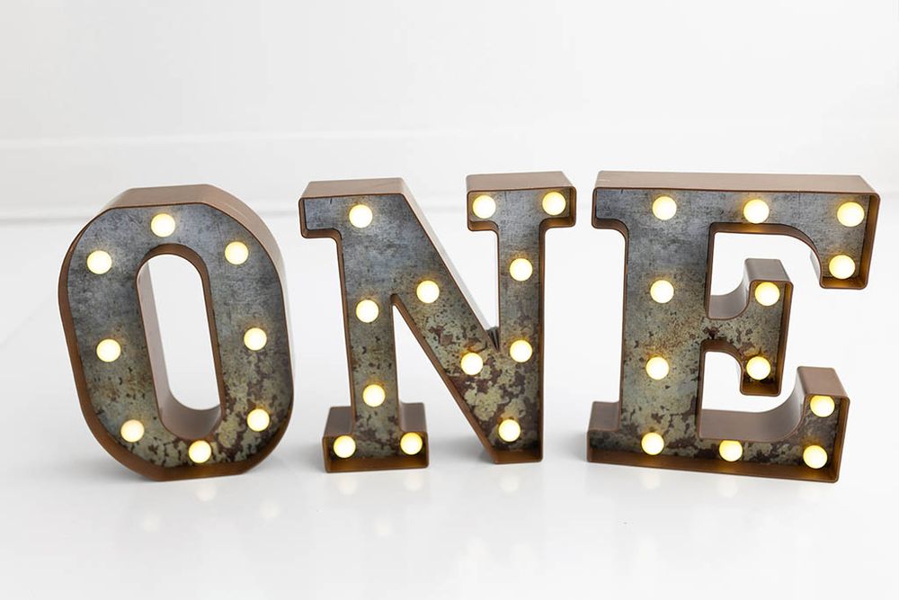 Rustic vintage marquee ONE light up letters; Cake smash photographer in Menifee, CA, specializing in baby's first birthday photos.