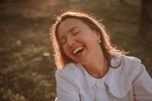 Joyful sunlit portrait with genuine laughter and backlit golden glow.
