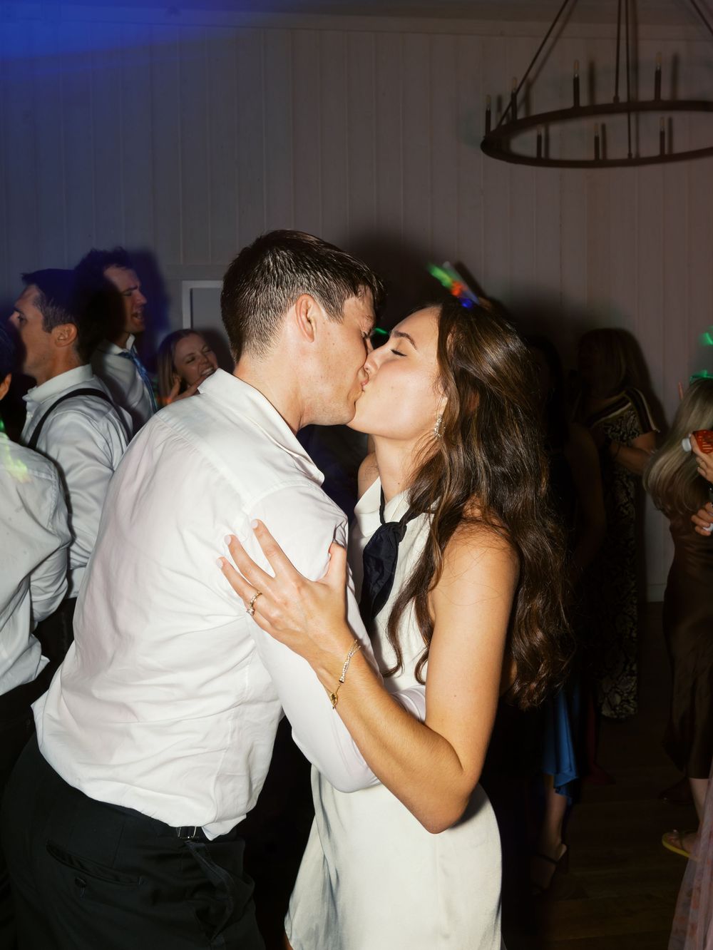 Newlyweds sharing a romantic kiss on the dance floor during their wedding reception.