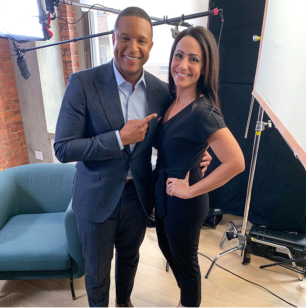 Two professionals smiling together in a modern studio setting with photography lighting equipment in the background.