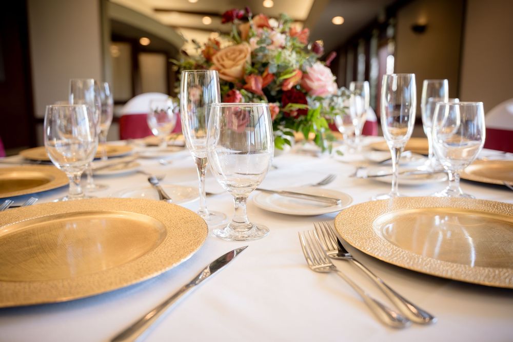 Red and gold wedding table decor at the Yolo Fliers Club in Woodland, California. Photo by Ashley Nicole Baeza, Woodland Wedding Photograph