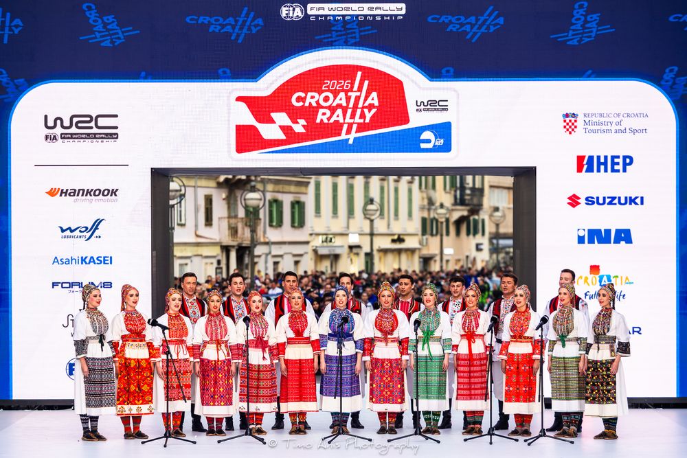 Traditional Croatian dancers in red folk costumes perform on stage at the 2024 WRC Croatia Rally opening ceremony.