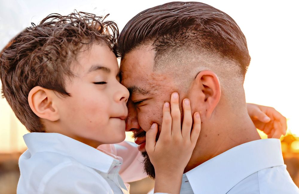 Close-up of a touching emotional moment between father and son during golden hour sunset taken by local photographer in Fresno,ca.
