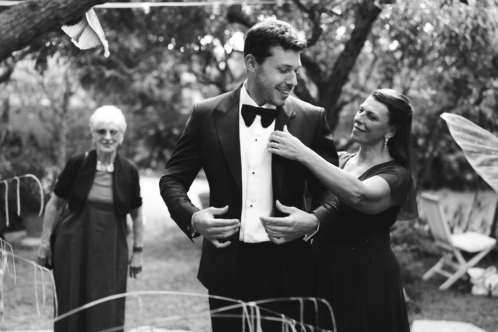 groom and his mother and granma dressing up for the wedding