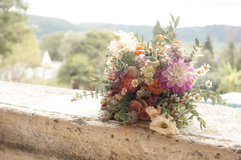 Colorful bridal bouquet with dahlias, roses and wildflowers at Château de Raysse,  by Dordogne  wedding photographer Laetitia KLOPOCKI