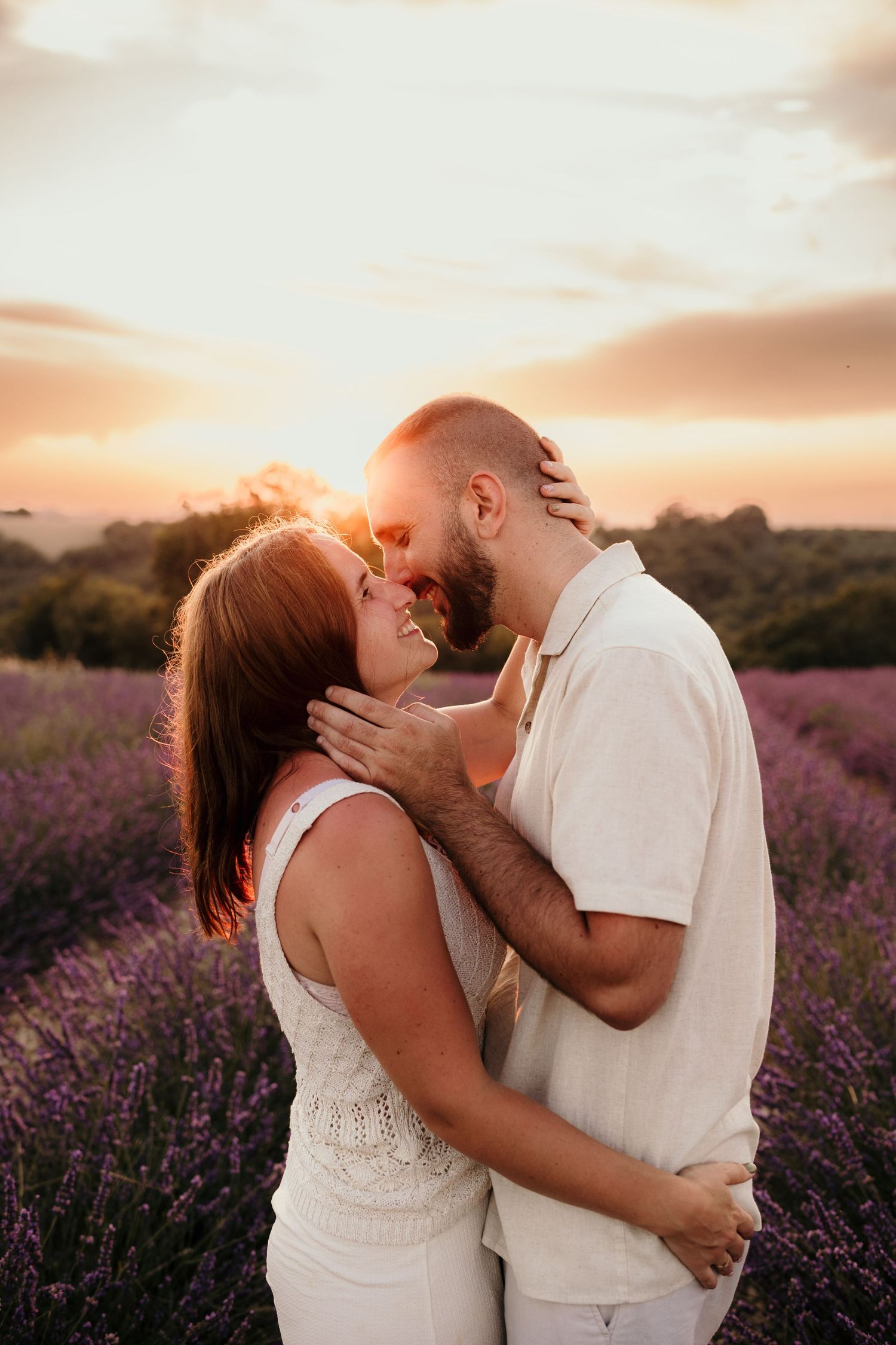Romantic sunset moment captured in a blooming purple lavender field with warm golden light filtering through the sky.