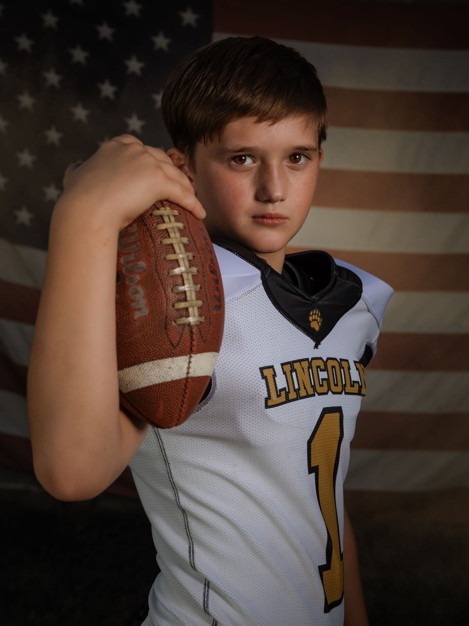Professional youth football portrait with American flag backdrop in Lincoln, Alabama.