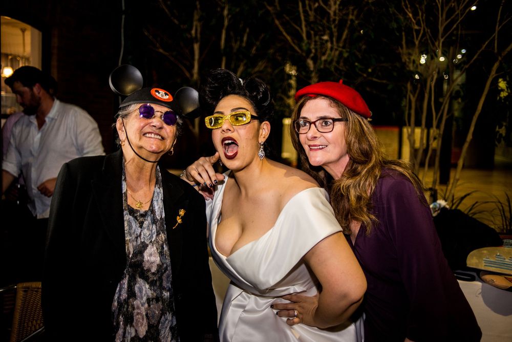 Fun party guests pose with props and silly expressions during wedding reception.