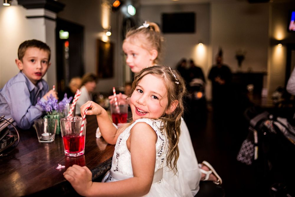 Children enjoying drinks at a wedding reception while sitting at the bar.