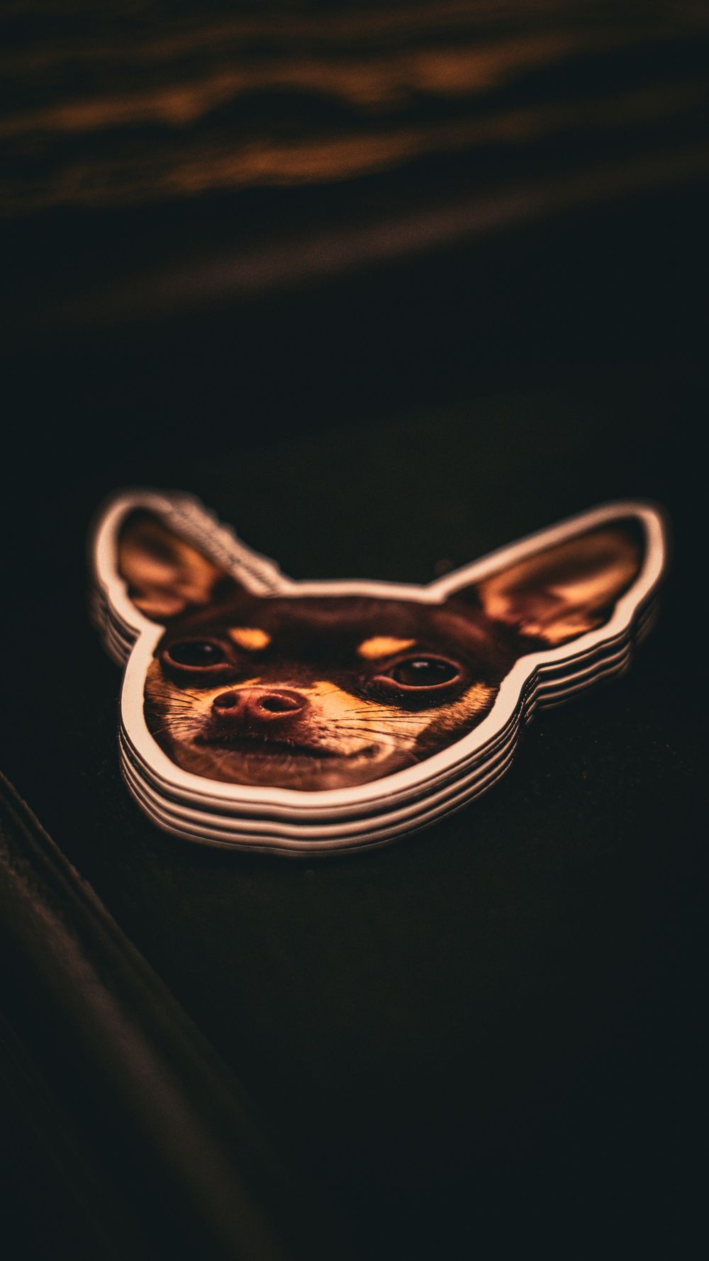 Artistic sticker design illuminated in warm lighting against dark background.