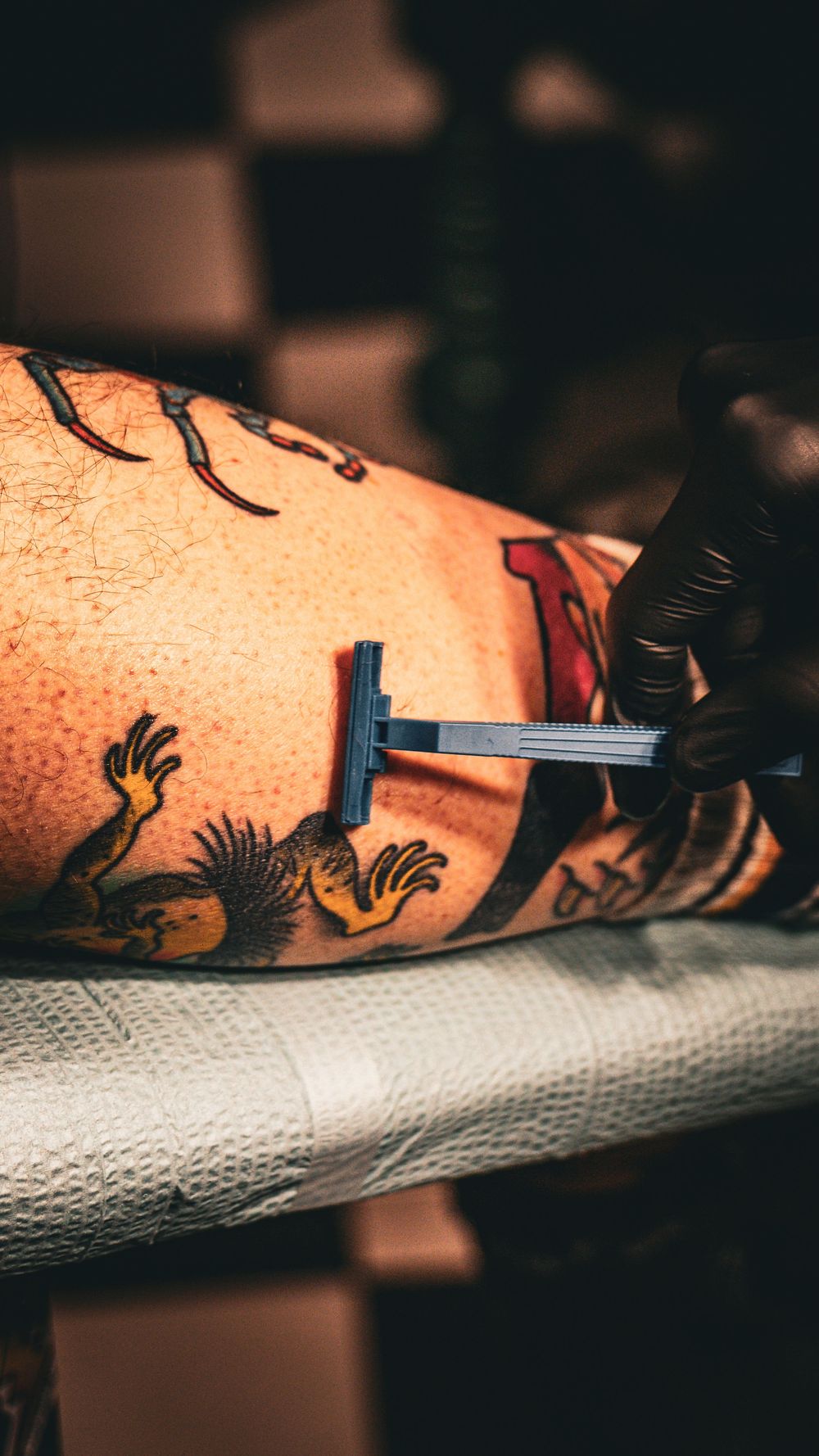 Colorful tattoo artwork on skin being worked on with tattoo machine.